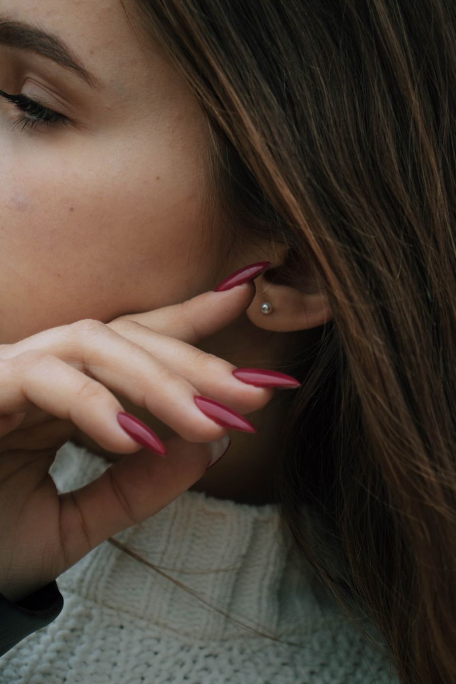 Rose manicure with a pearl earring and cream turtleneck